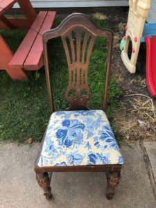 The original chair is brown with a yellow and blue paisley print.